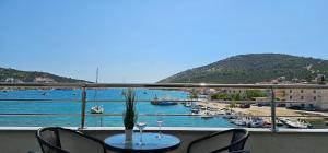 balcón con mesa y sillas y puerto en Beachfront Beauty, en Vinišće