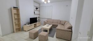 uma sala de estar com um sofá e uma televisão em J&M Rooms em Shkodër