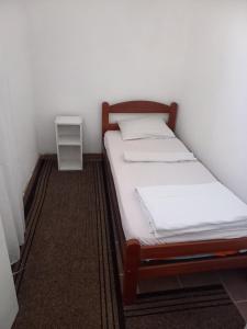 a small bedroom with two beds and a night stand at Hostel Dragana in Podgorica