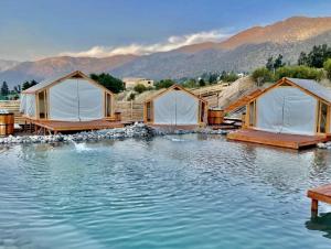 a row of luxury tents in the middle of the water at La villa Glamping in San José de Maipo