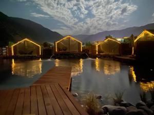 a row of luxury tents on a lake at night at La villa Glamping in San José de Maipo