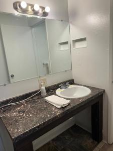 a bathroom counter with a sink and a mirror at Rama Inn in Washougal