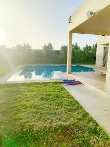 een achtertuin met een zwembad en een parasol bij ferme privé avec piscine in Safi