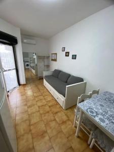 ein Wohnzimmer mit einem Sofa und einem Tisch in der Unterkunft Loft Marinella l'aereoporto di Lamezia sul mare Kitesurf in SantʼEufemia Lamezia