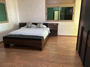 een slaapkamer met een bed en een houten vloer bij Villa SKYVIEW in Beni Mellal