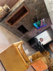een woonkamer met een bank en een televisie bij Villa SKYVIEW in Beni Mellal