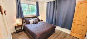- une chambre avec un lit doté de rideaux bleus et d'une fenêtre dans l'établissement 5 STAR King Bed Lux Cabin•Netflix & Hulu 4K UHD TV, à Broken Bow