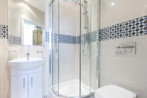 a bathroom with a shower and a toilet and a sink at Gower Hotel in London
