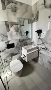 bagno con lavandino, servizi igienici e specchio di Vila Elite a Ksamil