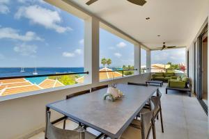 uma sala de jantar com uma mesa e vista para o oceano em SENSES Boutique Hotel & Apartments em Kralendijk