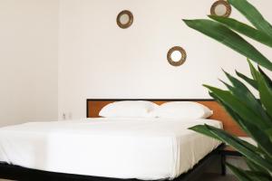 Un dormitorio con una cama con sábanas blancas y una planta en WUER Arco de la Calzada, en León