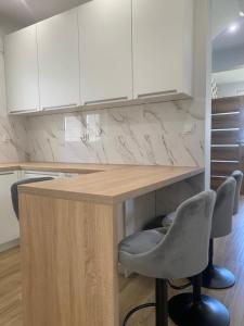 a kitchen with a table and two chairs and white cabinets at Biebrzańska Przystań 3 in Goniadz