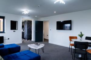 a living room with a blue couch and a table at Apartment by DH ApartHotels in Peterborough