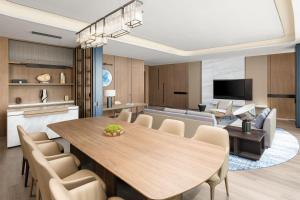 ein Esszimmer und ein Wohnzimmer mit einem Tisch und Stühlen in der Unterkunft Qingdao Marriott Hotel Jiaozhou in Qingdao