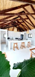 una cocina con techos y mesas de madera y una planta en Karula Sand Villas - Coral Villa - Barra Beach, Inhambane, Mozambique, en Inhambane