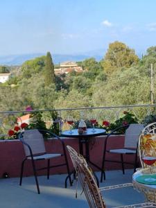 una mesa y sillas en un balcón con copas de vino en Villa Kontesa Kamara Corfu en Kamára