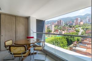 a dining room with a table and chairs and a large window at Borbon Suites in Medellín