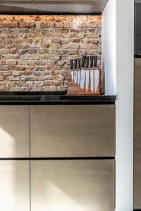eine Küchentheke mit Messern an einer Backsteinwand in der Unterkunft TheBridge29 boutique apartment in Breda
