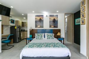 a bedroom with a large bed and a kitchen at Borbon Suites in Medellín