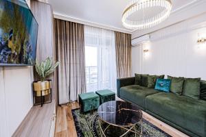 uma sala de estar com um sofá verde e uma mesa em New Oasis Premier-Inn flats em Chisinau