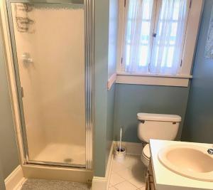 uma casa de banho com um chuveiro, um WC e um lavatório. em The House Hotels - Thoreau 2 em Lakewood