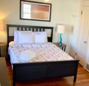 um quarto com uma cama grande e almofadas brancas em The House Hotels - Thoreau 2 em Lakewood