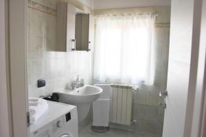 a white bathroom with a sink and a toilet at CA' GIALLA 5 - sul Lago di Lugano, Dog friendly, Balcone & Parcheggio - in Cadegliano Viconago +15 photos