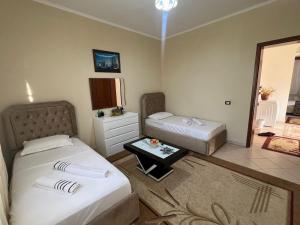 a hotel room with two beds and a table at G.L. Apartments in Berat