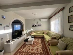 a living room with a couch and a tv at G.L. Apartments in Berat