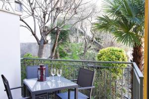 a table with two wine glasses on a balcony at CA' GIALLA 5 - sul Lago di Lugano, Dog friendly, Balcone & Parcheggio - in Cadegliano Viconago