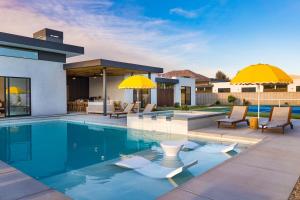 basen z leżakami i parasolami obok domu w obiekcie The Reserve at Polo Villas 18 by AvantStay w mieście La Quinta