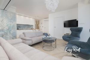ein Wohnzimmer mit Sofa, Stühlen und einem Tisch in der Unterkunft Double Blue Bien - Easy-Rent Apartments bezpośrednio przy plaży in Rewal