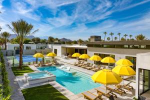 拉昆塔的住宿－The Reserve at Polo Villas 15 by AvantStay，一张酒店图画,上面有黄色的遮阳伞和一个游泳池