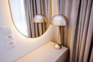 duas lâmpadas sentadas numa mesa em frente a um espelho em New Oasis Premier-Inn flats em Chisinau