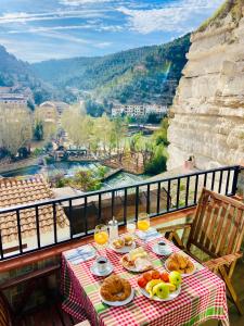 a table with food and wine glasses on a balcony at Casa Rural Los Amaneceres in Alcalá del Júcar