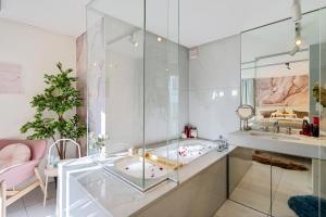 ein Glasbadezimmer mit einer Badewanne und einem Waschbecken in der Unterkunft Boutique Design-Suite-Apartment at best central Location in Zürich