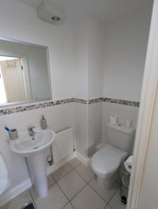 a white bathroom with a toilet and a sink at 83 in Bournemouth