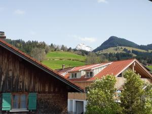 un groupe de maisons avec des montagnes en arrière-plan dans l'établissement Berggasthof Sonne Allgäu, à Sonthofen