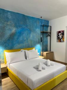 EMAAR Hotel Ksamil - BEACHFRONT , Newly Renovated في كساميل: غرفة نوم بسرير مع جدار ازرق