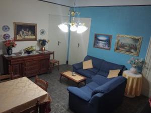 een woonkamer met een blauwe bank en een tafel bij La locanda in Cefalù