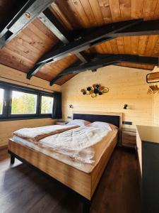 艾蓋爾紹洛克的住宿－BeLaWood，一间带一张大床的卧室,位于一个拥有木制天花板的房间