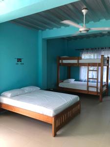 2 Etagenbetten in einem Zimmer mit Deckenventilator in der Unterkunft CABAÑAS CRAZY COCONUTS in San Antero