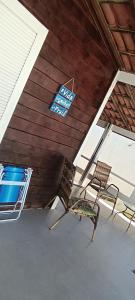 duas cadeiras num alpendre com uma placa no tecto em Casa de praia no sossego em Ponta do Funil