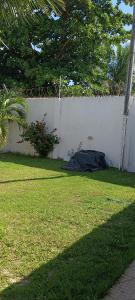 um quintal com uma cerca branca e um quintal com relva em Casa de praia no sossego em Ponta do Funil