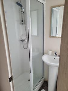 a bathroom with a shower and a sink at Highfield Grange Holiday Park in Little Clacton
