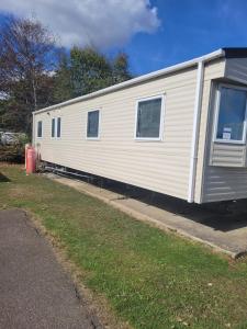 a white trailer is parked in a driveway at Highfield Grange Holiday Park in Little Clacton