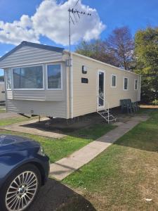 a mobile home is parked in a yard at Highfield Grange Holiday Park in Little Clacton