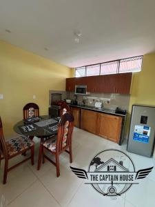a kitchen with a table and two chairs and a kitchen with a kitchen at The Captain House in Pucallpa