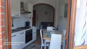 uma cozinha com uma mesa e uma cozinha com um fogão em casa Dany em Perugia