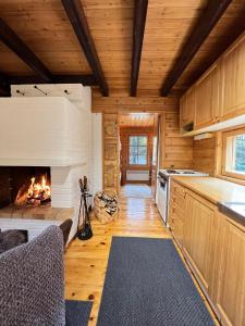 a kitchen with a fireplace in a log cabin at Villa Aiku in Leppäjärvi